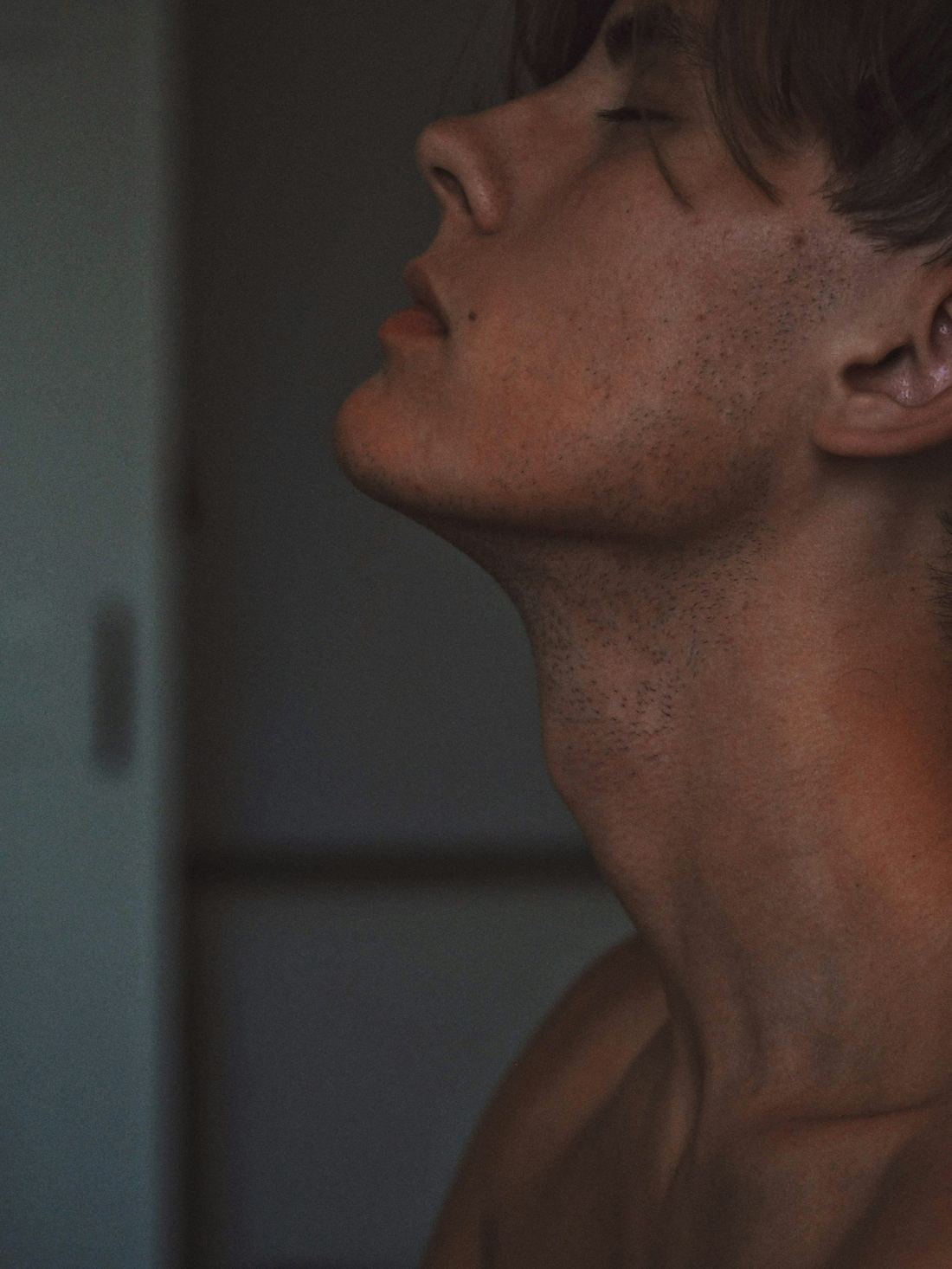 A young man with eyes closed and chin raised, breathing slowly