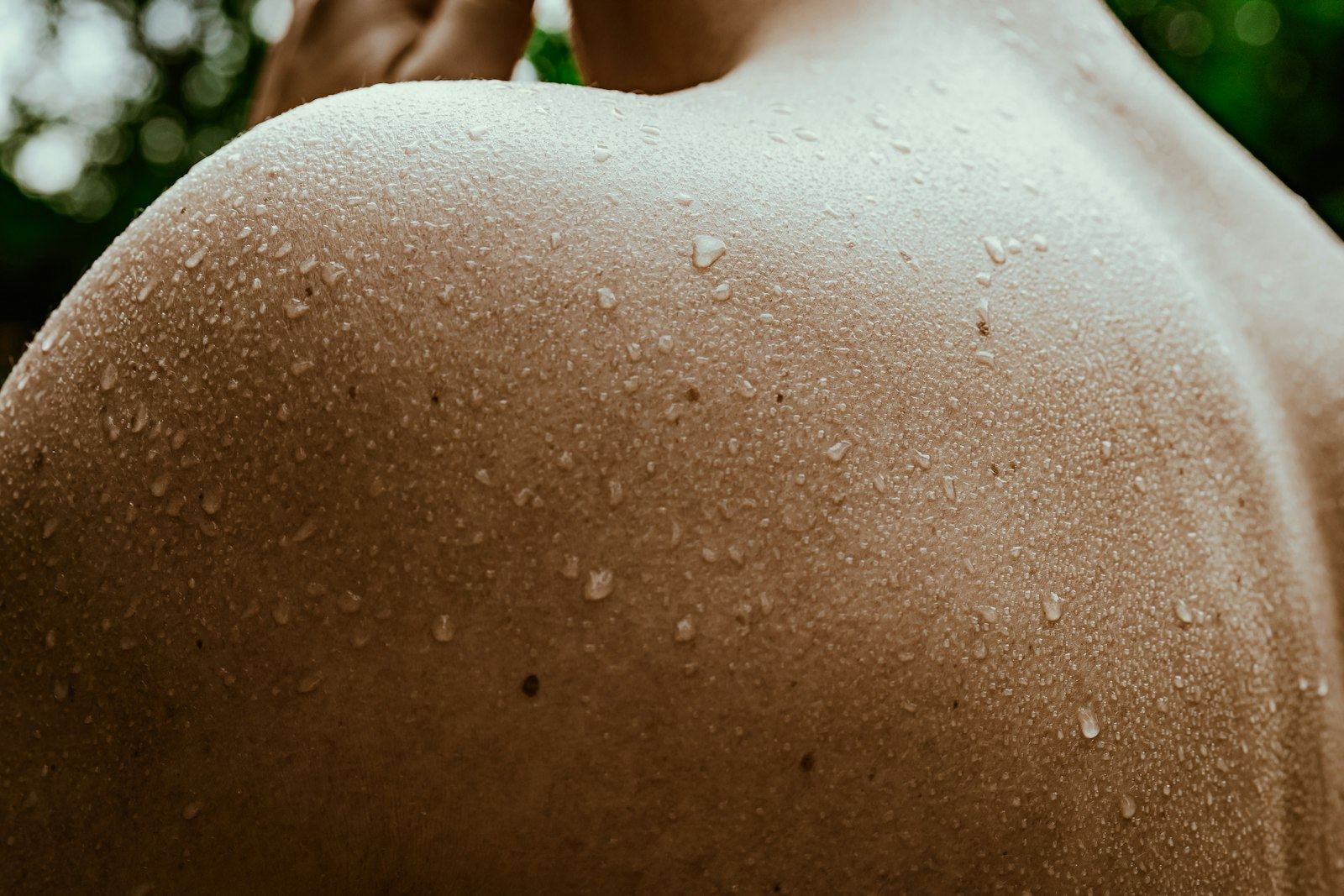Close-up of beads of sweat on a bare shoulder